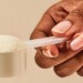 hand holding a scoop of collagen peptides powder