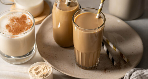 Glasses filled with keto iced coffee protein shake next to collagen scoop