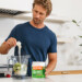 man adding collagen protein powder to a blender