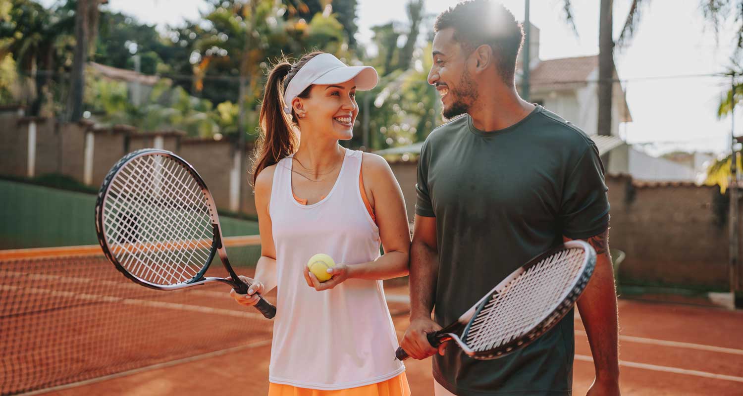 happy couple playing tennis