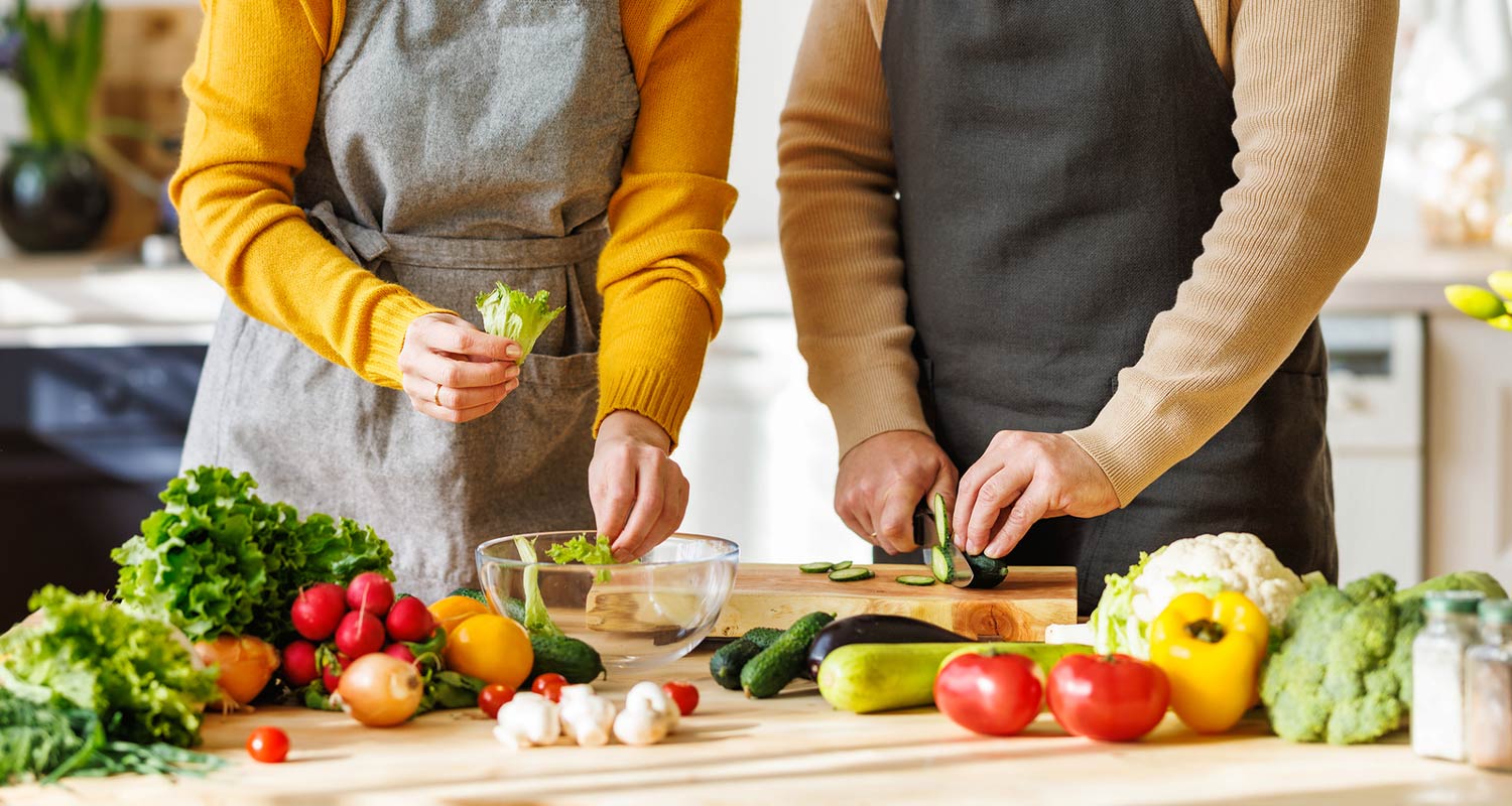 two people cutting vegetables