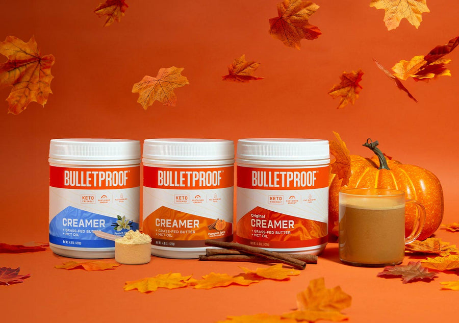 Fall favorites, Bulletproof creamers on display with orange leaves falling around them and a pumpkin and cup of coffee beside.