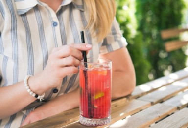 Woman with pink drink at table